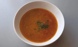Подача супа из красной чечевицы в белой тарелке