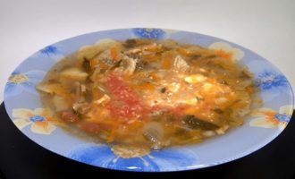 Подача супа из капусты и мяса в голубой тарелке