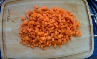 Морковь нарезанная кубиками на деревянной доске