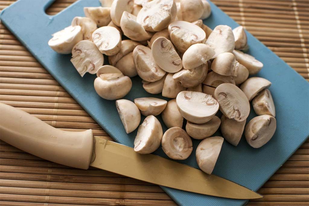 Порежьте грибы на четвертинки или дольки, в зависимости от вашего рецепта
