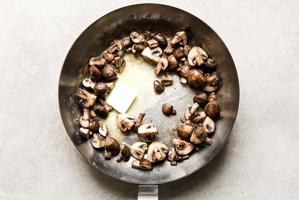Обжарьте грибы в оставшемся сливочном масле